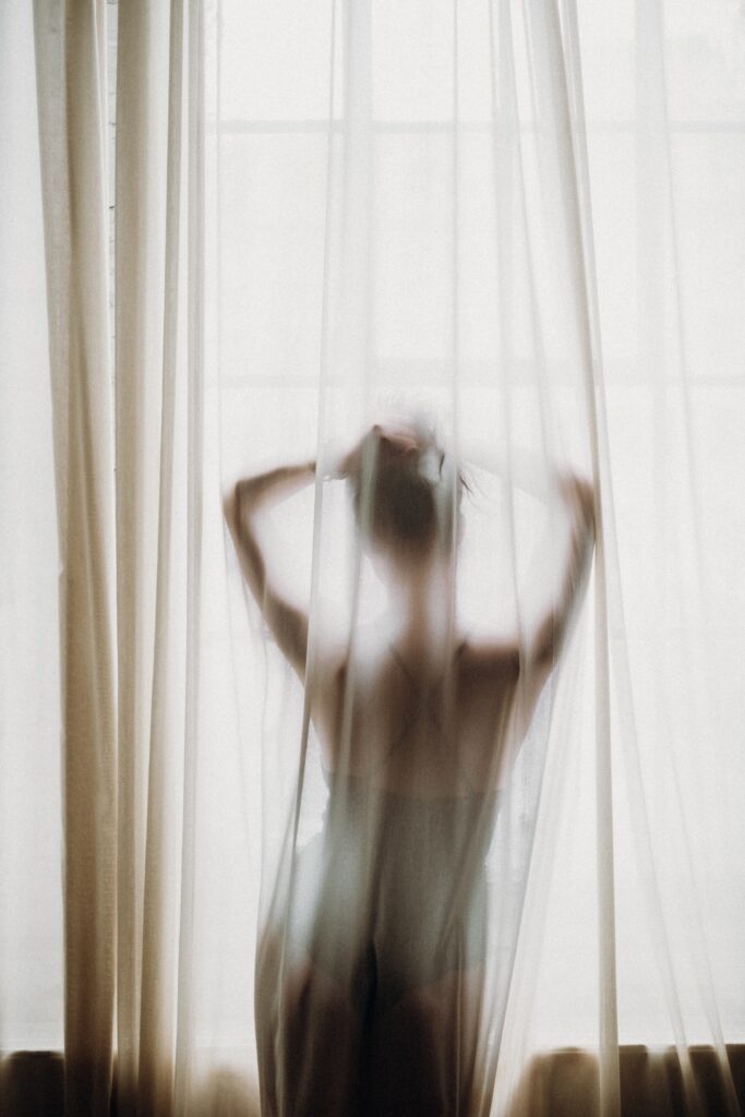 girl standing behind a curtain