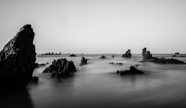 black and white photo of rocks in the sea
