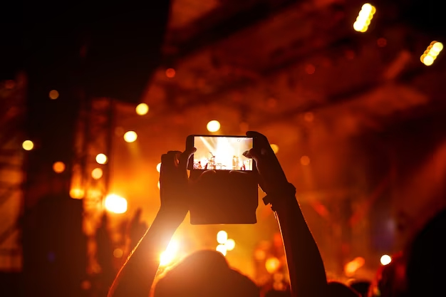 Fan taking photo of concert at festival by smatphone