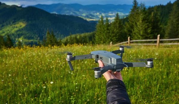 Drone in Hand on a Field Background
