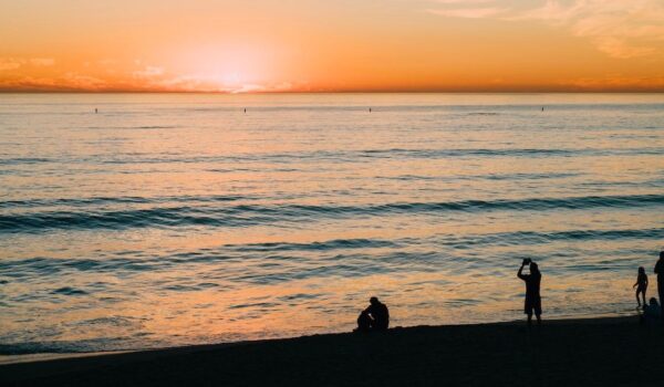 A breathtaking view of the sun rising over the calm ocean, casting warm golden light on the water