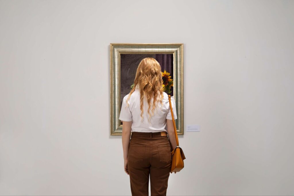 A woman is standing in front of the painting