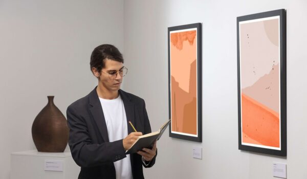 A man writes down his thoughts in a notebook at an exhibition