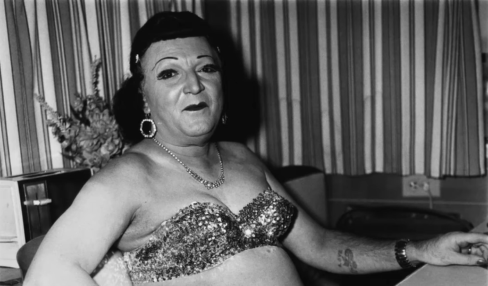 Man wearing women's clothes, sitting in a bra and makeup